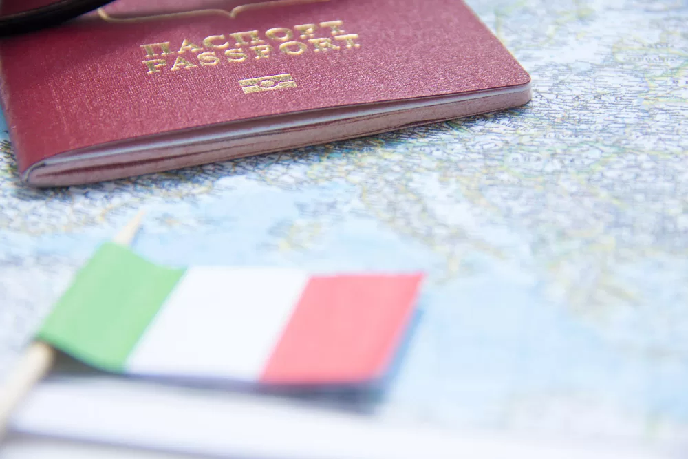 conceito de ferias oculos de sol pequena bandeira e passaporte da italia no mapa jpg
